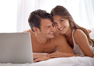 Buy stock photo Laptop, love and happy couple lying in bed together while watching a online movie or video at home. Happiness, smile and portrait of a woman browsing the internet on computer with husband in bedroom.