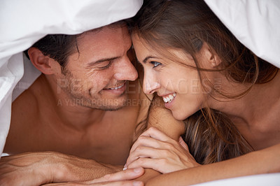 Buy stock photo Love, happy and couple in bed, waking up and bonding in a bedroom together, flirting and romantic. Romance, man and woman relax, intimate and resting at hotel for valentines day, anniversary or bond
