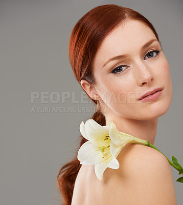 Buy stock photo Portrait, skincare and woman with flower, lily and natural beauty isolated on a gray studio background mockup. Face,   organic and ginger model with floral cosmetics for glow, wellness and makeup