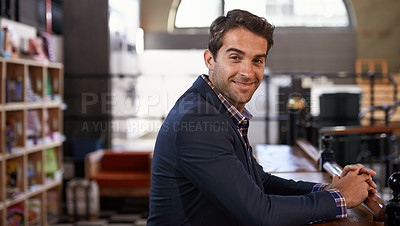 Buy stock photo Shot of a young man sitting in a coffee shop