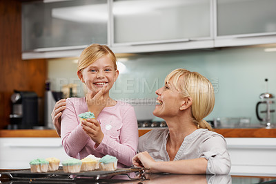 Buy stock photo Happy, mom and child with cupcake in kitchen and portrait of baking together in home to relax. Family, bonding and kid smile with mother, excited for eating cake, sweets or enjoy food in house