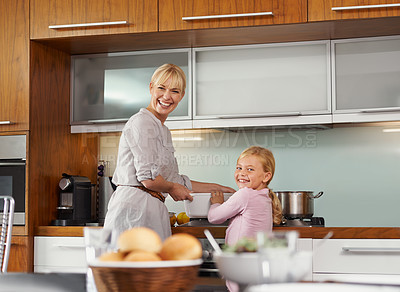 Buy stock photo Portrait of an attractive young woman in the kitchen with her adorable daughter