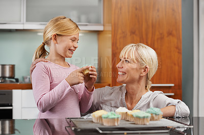 Buy stock photo Happy, mom and child with cupcake in kitchen and learning about baking together in home to relax. Family, bonding and kid smile with mother, excited for eating cake, sweets or enjoy food in house