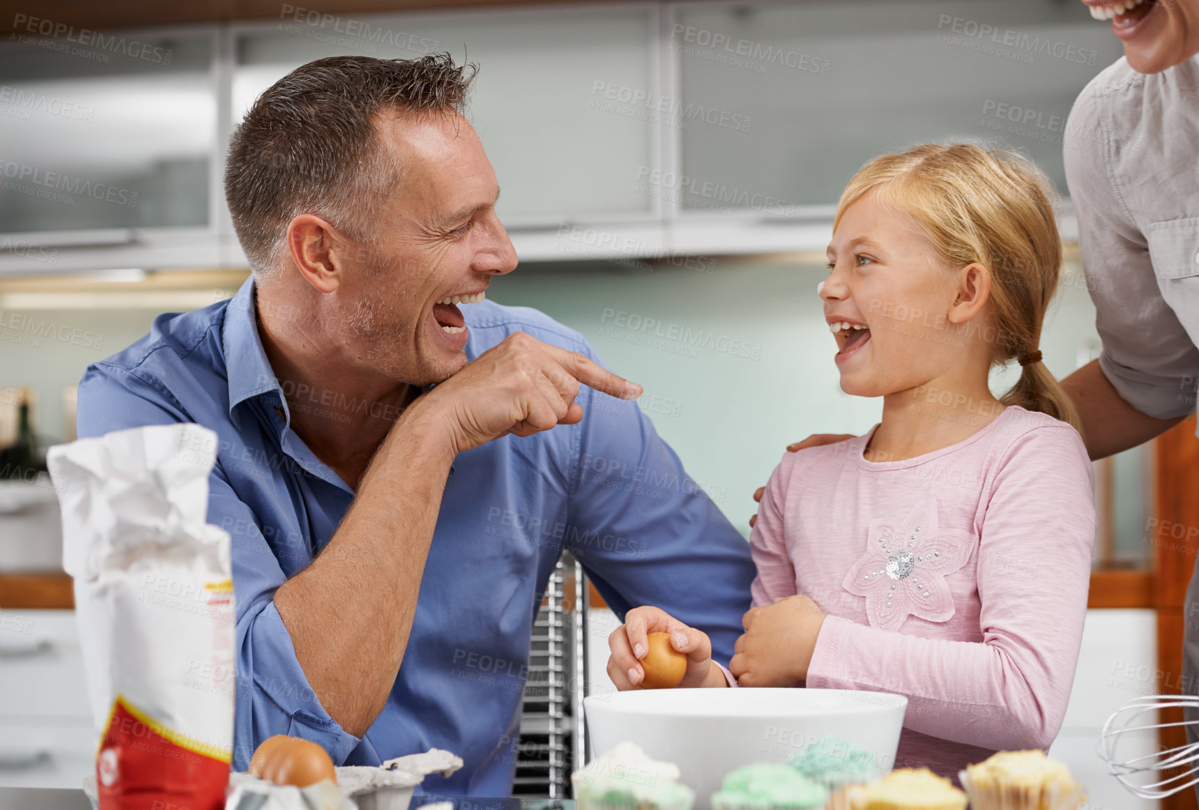 Buy stock photo Shot of a family baking together and laughing