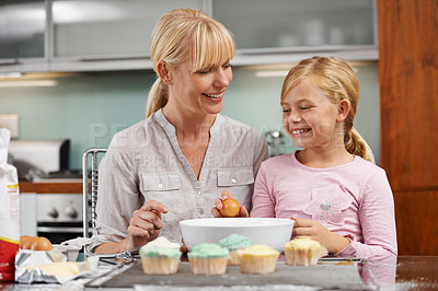 Buy stock photo Baking, mom and child with cupcake in kitchen and teaching skill in home together to relax. Family, bonding and kid smile with mother, excited for eating cake, sweets or preparing with egg in house