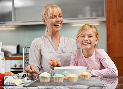 Buy stock photo Baking, cupcake and portrait with child and mom in kitchen to relax in home together on holiday. Family, bonding and kid smile with frosting on face and mother laughing and enjoy food prep in house