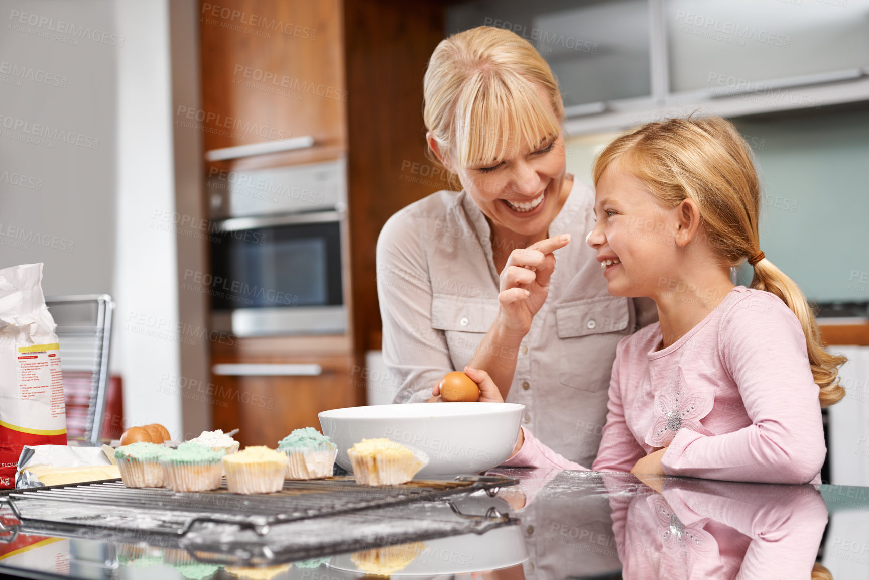 Buy stock photo Cropped shot of an attractive young woman baking with her adorable daughter
