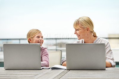 Buy stock photo Shot of a young girl and her mother using laptops side by side