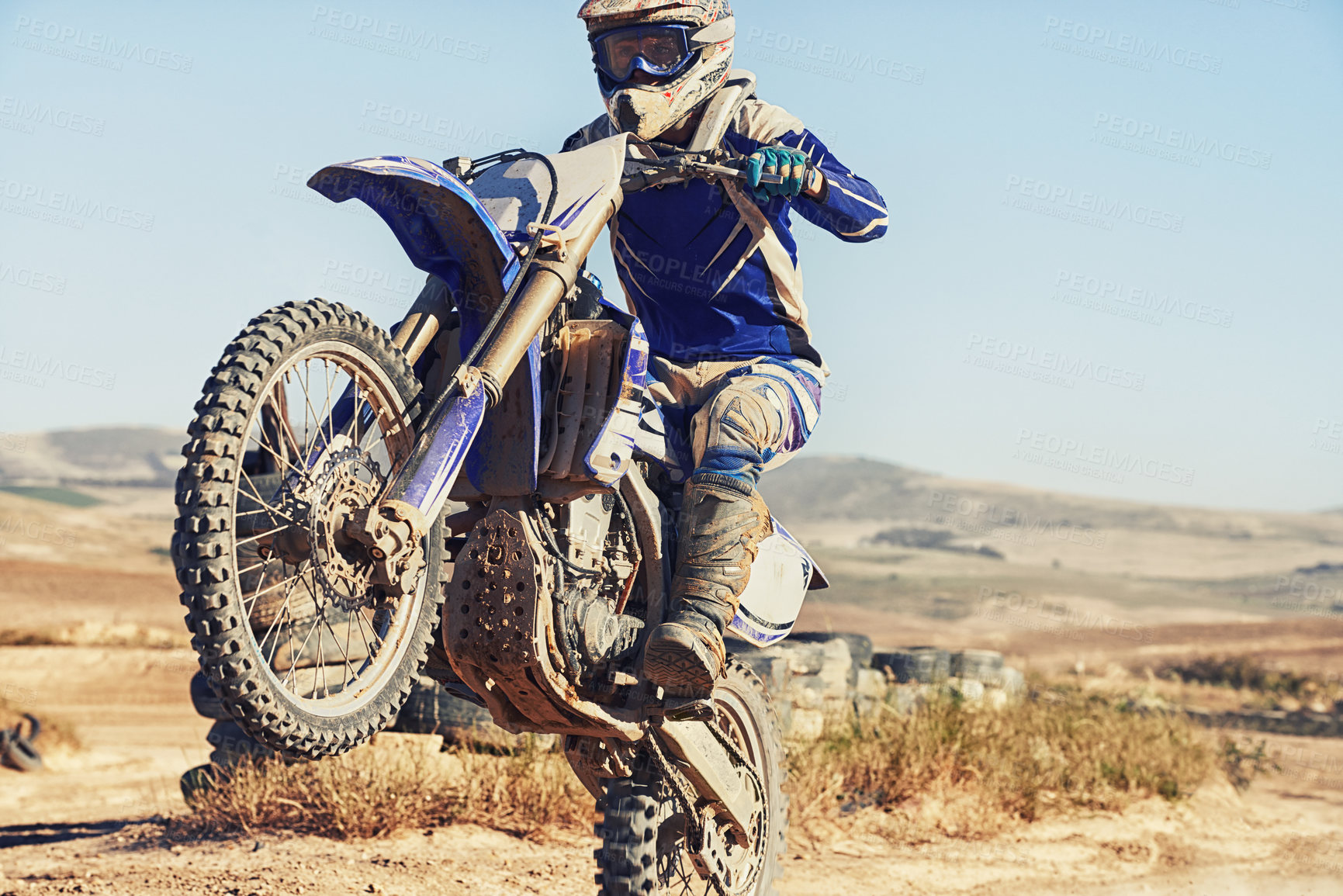 Buy stock photo Motorbike, action and balance, person with speed and skill for adrenaline and stunt with extreme sports outdoor. Competition, adventure and power with risk, biker riding on motorcycle with wheelie