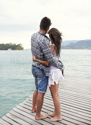 Buy stock photo Couple, jetty and embrace by ocean on vacation, love and relax by water on summer holiday. People, hug and bonding for relationship in outdoors, support and back on weekend trip to sea or nature