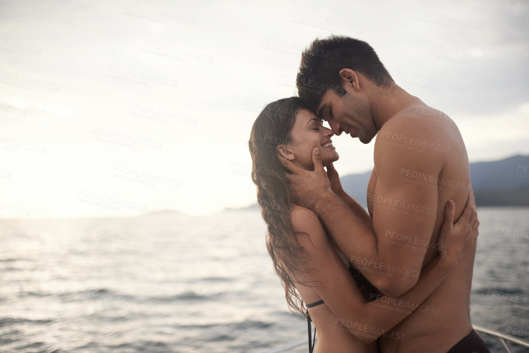 Buy stock photo Love, smile and couple at ocean at sunset for vacation, holiday or travel together in summer. Happy man, woman and hug at sea for connection, care and touch forehead on adventure by water on mockup
