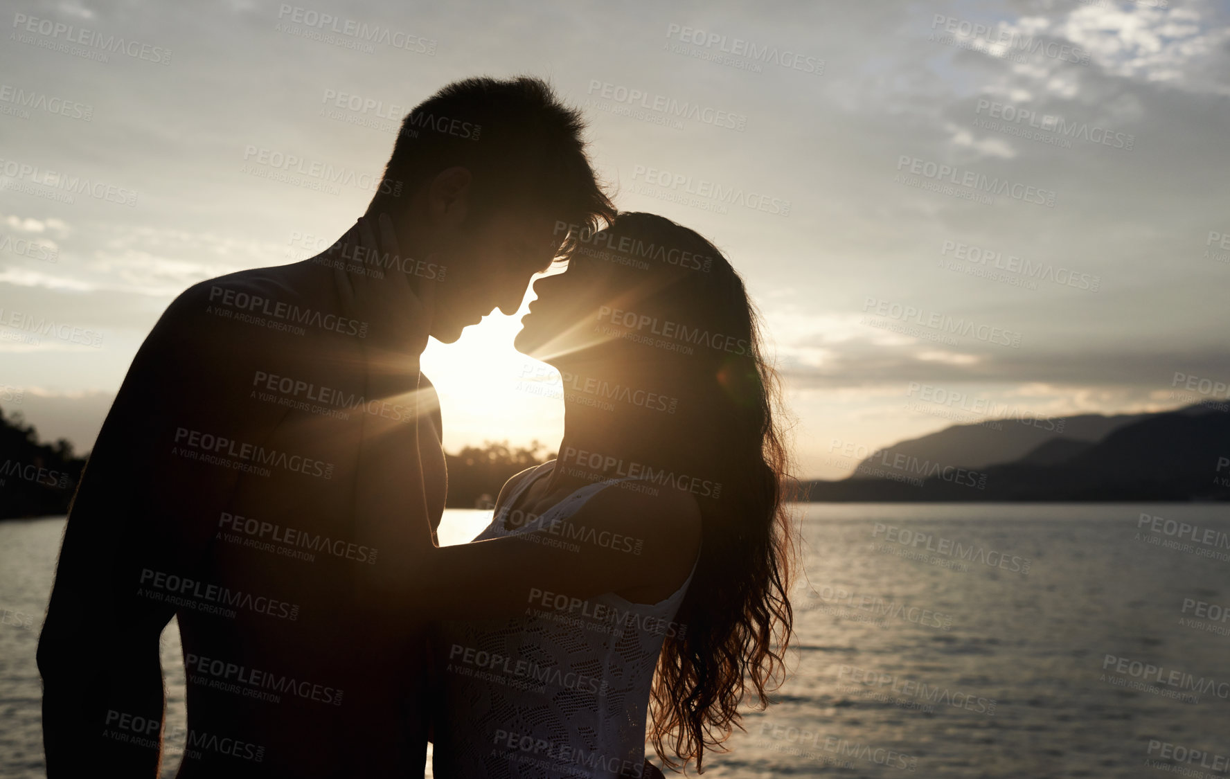 Buy stock photo Silhouette, couple and love by ocean at sunset, vacation or travel together in summer. Man, woman and romance at sea with shadow for connection, relationship and adventure by water outdoor in nature