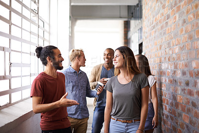 Buy stock photo Shot of a diverse group of university friends talking in a hallway