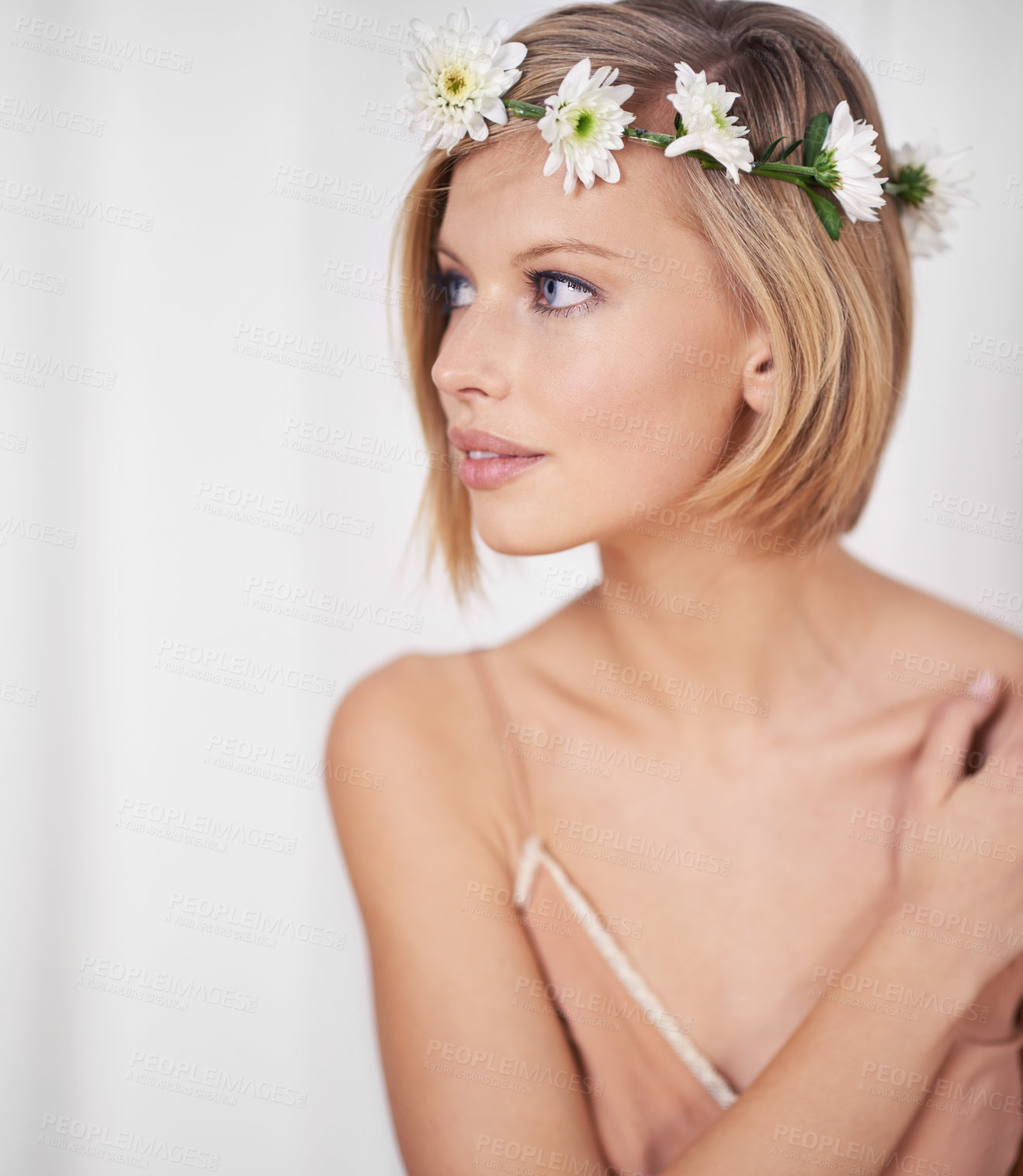 Buy stock photo A beautiful young woman wearing a flower crown and looking thoughtful