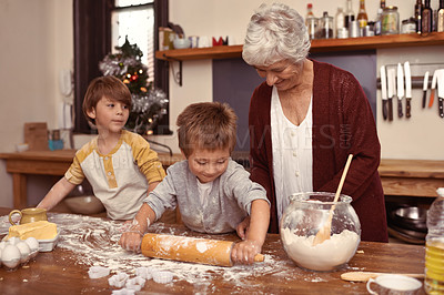 Buy stock photo Grandmother, smile and kids baking in kitchen, learning or happy boys bonding together in home. Grandma, children and cooking with flour, rolling pin or messy brothers having fun with family at table
