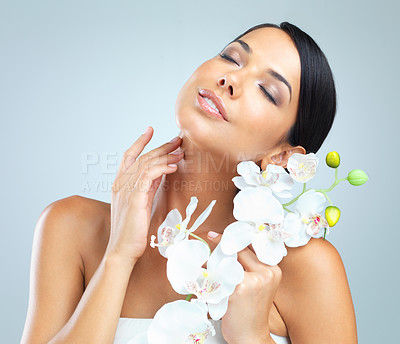 Buy stock photo Flowers, skincare and woman with shine, cosmetics and person on grey studio background. Model, luxury or girl with aesthetic or natural with facial or dermatology with glow or soft skin with wellness