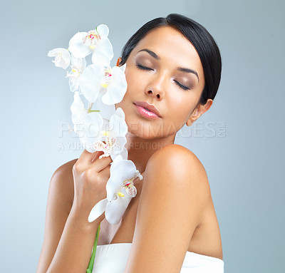 Buy stock photo Flowers, wellness and woman with beauty, dermatology and person on grey studio background. Model, plants or girl with aesthetic or natural with facial or shine with glow or smooth skin with cosmetics