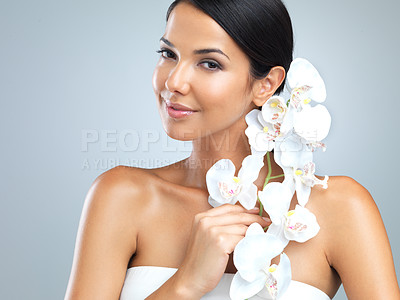 Buy stock photo Portrait, woman and beauty with flower for confidence on studio, grey background and satisfied with makeup. Female person, soft and natural for smooth skin with eco friendly, sustainable and smile 