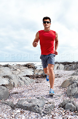 Buy stock photo Athlete male person, running and beach for fitness, health and wellness in activewear and sunglasses. Man, jog and seaside for sport, training and workout exercise for cardio outdoor routine 