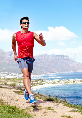 Buy stock photo Man, beach and earphones for running outdoors, sports and athlete for performance training by sea. Male person, full body and sunglasses for workout in nature, cardio and listen to music for exercise