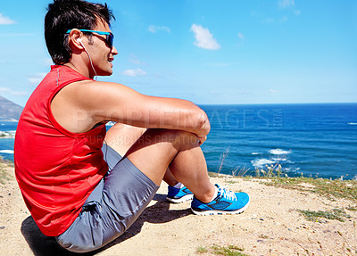 Buy stock photo Runner, man and earphones to relax at beach with rest, break or breathing with music in summer sunshine. Person, listening and streaming with subscription with workout, memory and sitting by ocean
