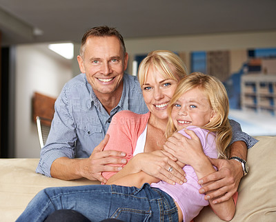 Buy stock photo Shot of a loving family embracing each other on the sofa