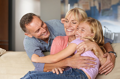 Buy stock photo Excited, child and parents on sofa for love, relax and bonding together for calm peace on weekend. Father, mother or daughter for happy family with care, vacation or affection with hugging in lounge