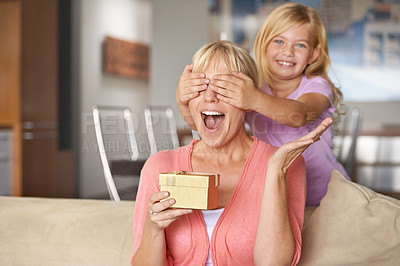 Buy stock photo Mothers day, surprise and daughter with gift, sofa and smile in house while closing eyes and excited. Mom, kid and present on sofa, home and happy for birthday or playing peekaboo for love and fun