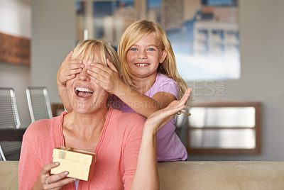 Buy stock photo Mothers day, excited and daughter with surprise, sofa and smile in house while closing eyes and gift. Mom, kid and present on couch, home and happy for birthday or playing peekaboo for love and fun