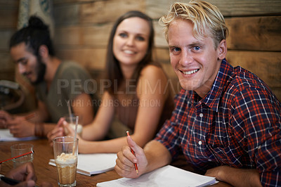 Buy stock photo Portrait, student and happy man writing at coffee shop, learning and friends studying together in university. Face, group and education at cafe for college exam, test and collaboration with diversity