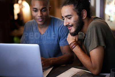 Buy stock photo Cropped shot of two male friends using a laptop in a coffee shop