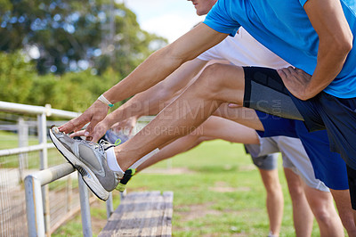Buy stock photo Group, people and outdoor for stretching legs on bench for warm up, workout and training together on grass. Sports, team and exercise on field for health, wellness and fitness in nature with friends