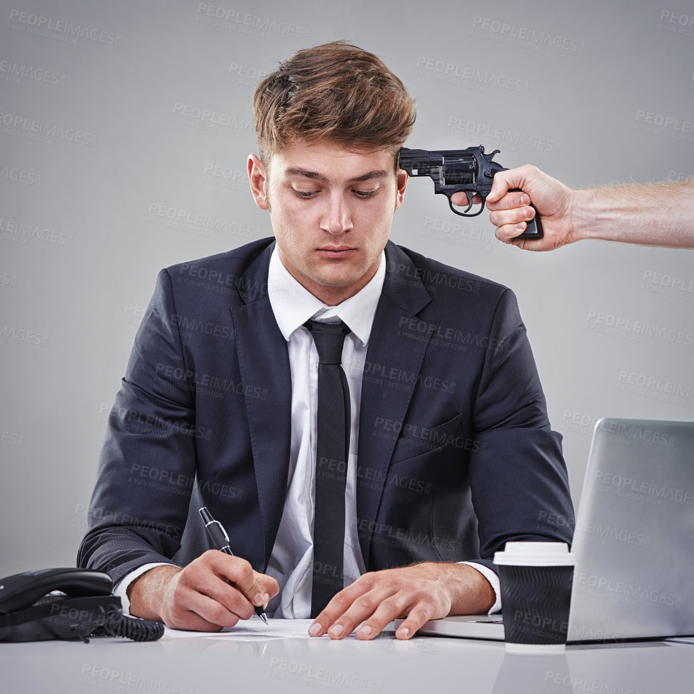 Buy stock photo A business man signing a piece of paper with someone pointing a gun at his head