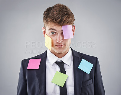 Buy stock photo Business man, overwhelmed and sticky note on face, suit or clothes in studio portrait by background. Person, employee or corporate staff with paper, reminder or ideas for schedule, meeting or report