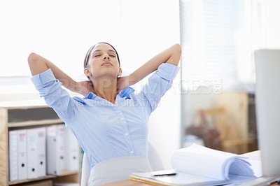 Buy stock photo Shot of young businesswoman taking a moment to relax at her desk