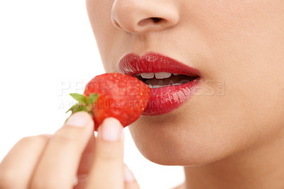 Buy stock photo Cropped closeup shot of a young woman with red lips eating a strawberry