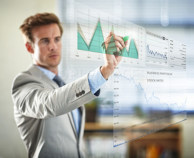 Buy stock photo Cropped shot of a handsome young businessman plotting graphs using a digital interface