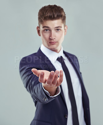 Buy stock photo Concept studio shot of a young businessman standing with his open palm raised to the camera