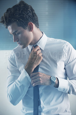 Buy stock photo Cropped shot of a handsome young businessman getting ready for work