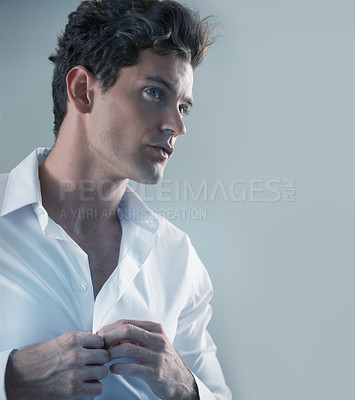 Buy stock photo Thinking, shirt and business man getting ready in studio isolated on gray background for start of career. Face, fashion and button with serious young employee dressing in outfit for interview