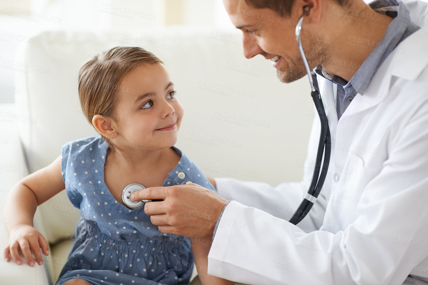 Buy stock photo Shot of a handsome male doctor with an adorable young girl for a  patient