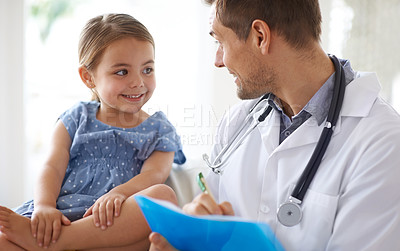 Buy stock photo Shot of a handsome male doctor with an adorable young girl for a patient