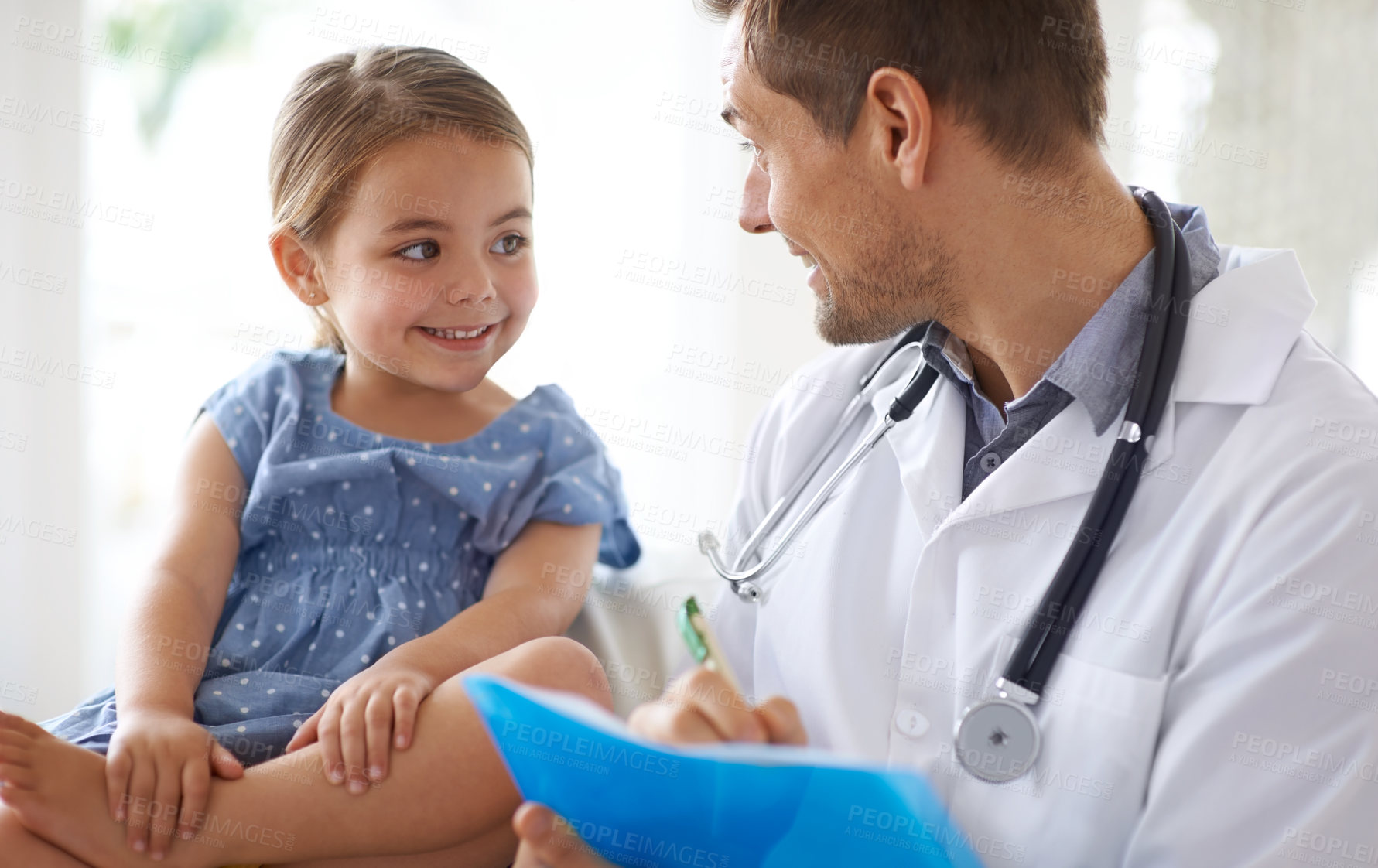 Buy stock photo Shot of a handsome male doctor with an adorable young girl for a patient