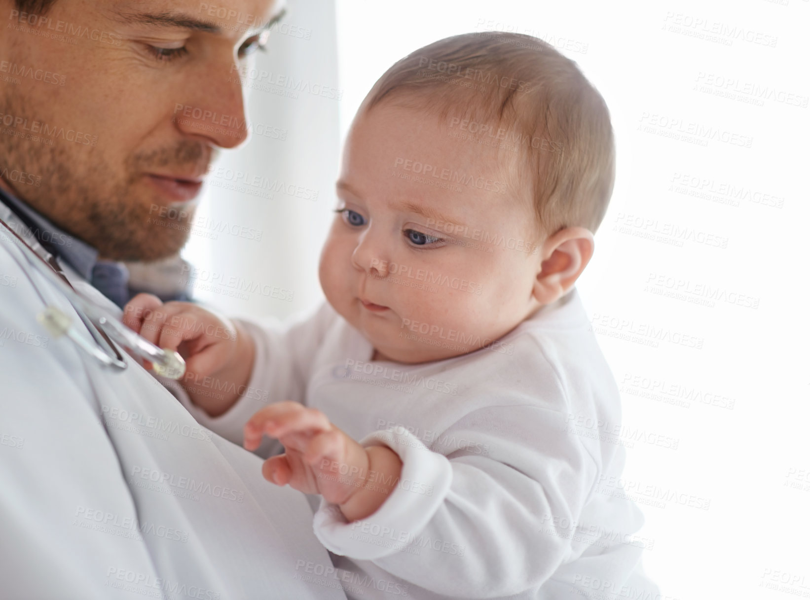 Buy stock photo Doctor, pediatrician and baby playing with stethoscope for healthcare assessment, medical support and growth. Newborn kids, man and pediatrics service in clinic, hospital and playful children