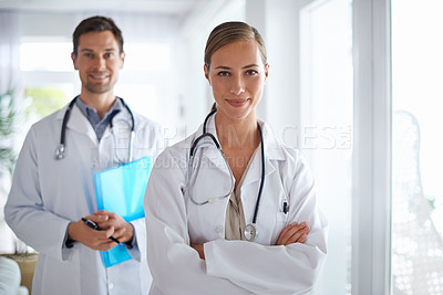 Buy stock photo Portrait of two smiling doctors standing in a hospital