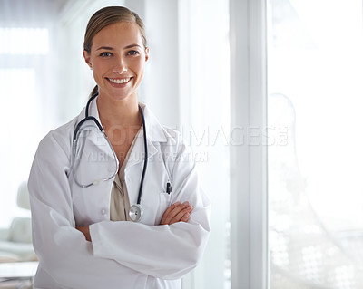 Buy stock photo Portrait of an attractive young doctor standing with her arms folded