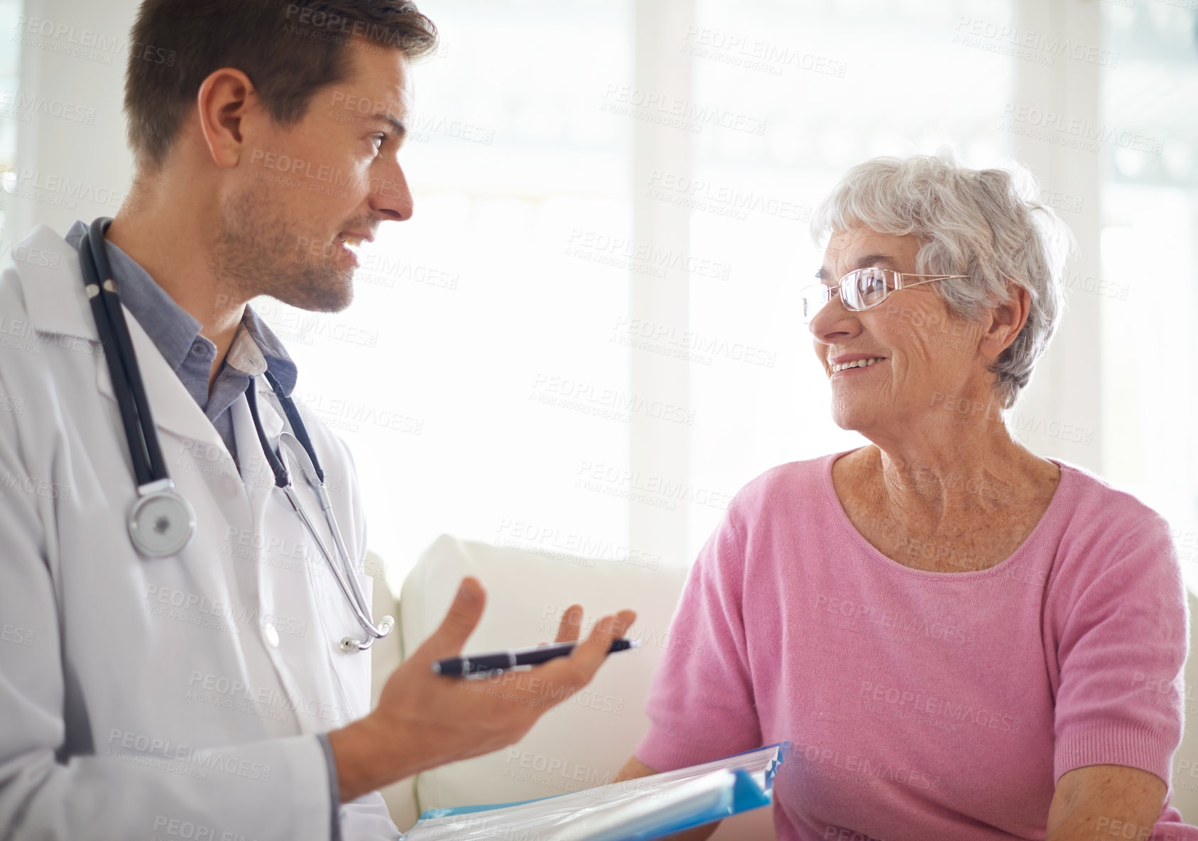 Buy stock photo Shot of a male doctor explaining something to his senior patient