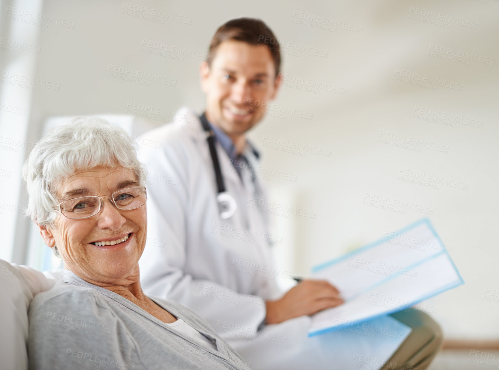 Buy stock photo Shot of a handsome male doctor with a happy elderly patient