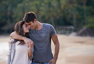 Buy stock photo An affectionate young couple on a calm and tranquil beach