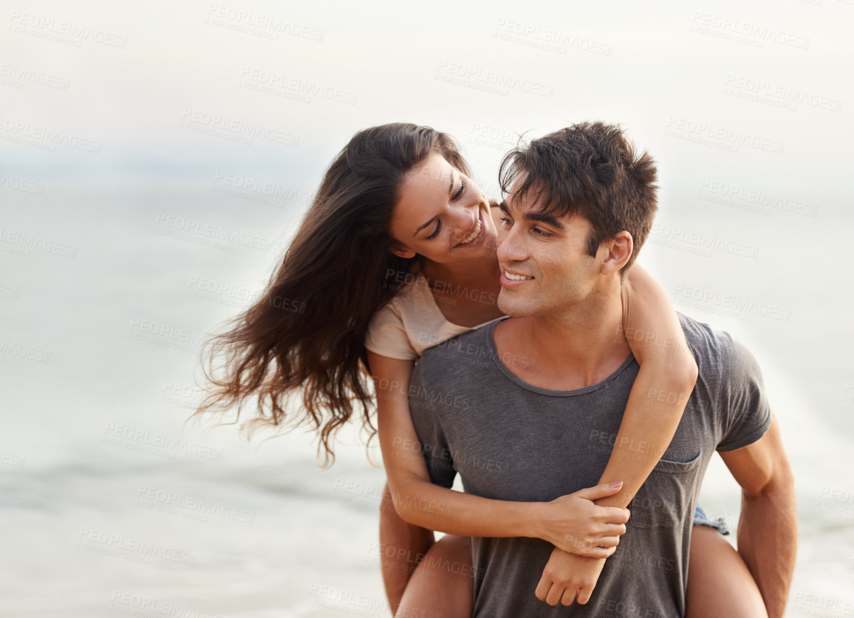 Buy stock photo Cropped shot of an affectionate young couple at the beach